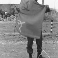 Officer shows a Shining Path flag removed from a streetlight pole