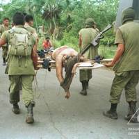 Armed Forces personnel transport the body of a victim of Operation Aries